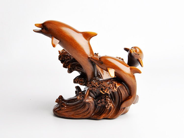 Wooden sculpture of a dolphin and bird on a wave